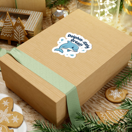 Wooden gift box with a green ribbon and 'Dolphin Itty Bitty' sticker on a festive background with cookies and lights.